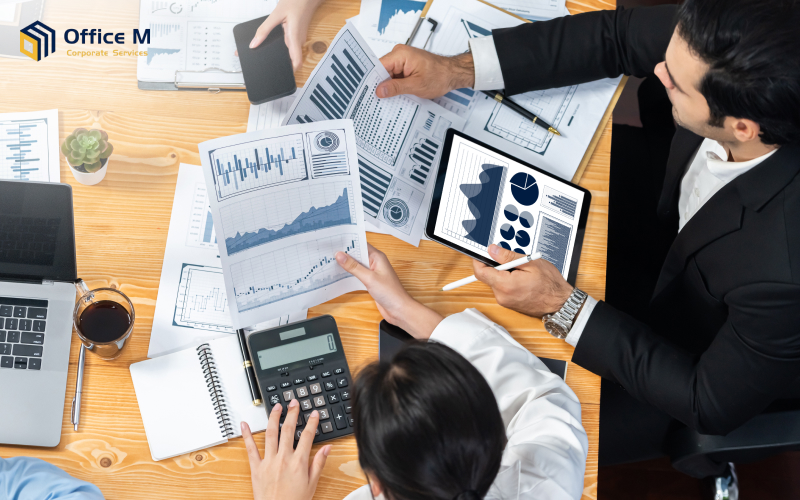 Business executives analyzing financial reports and charts from Office M.