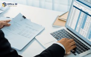 Business man doing SME accounting on a laptop spreadsheet.