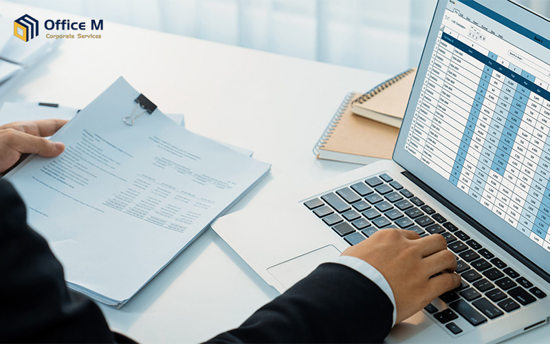 Business man doing SME accounting on a laptop spreadsheet.