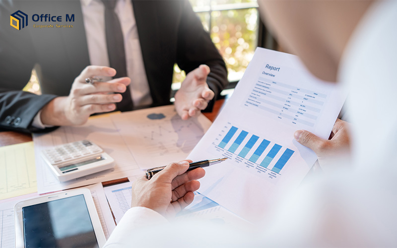 Business professionals discussing a printed financial report with charts during a meeting.