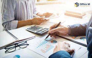 Professionals reviewing financial reports and charts at Office M.