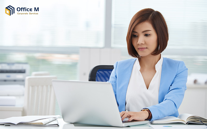 An office lady is doing admin work with her laptop