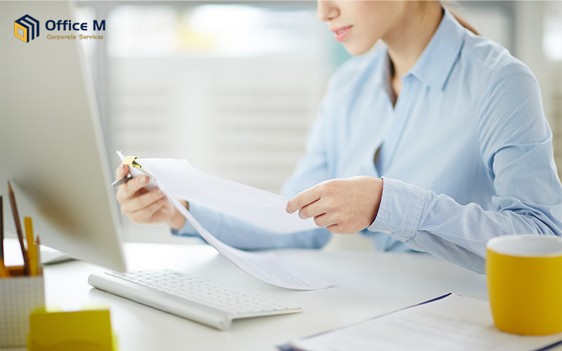 Organized stacks of corporate documents and financial records prepared for annual return filing by a newly incorporated company