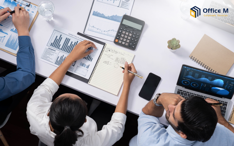 Professionals discussing marketing and financial data at a meeting for Office M.