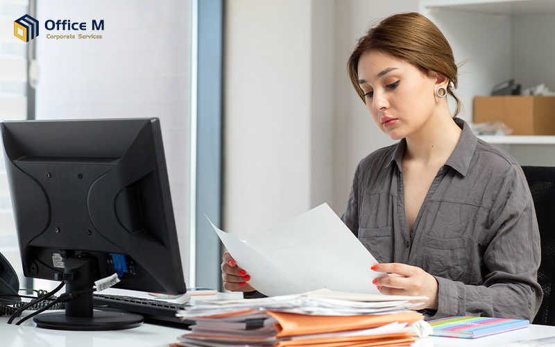 A woman reviewing corporate tax documents at her desk