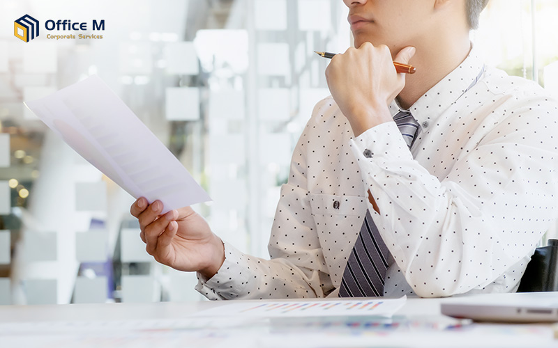 A male executive reviewing a corporate tax report.
