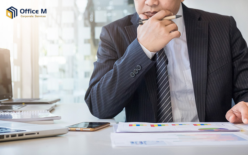 A businessman reviewing tax computation charts on his desk.