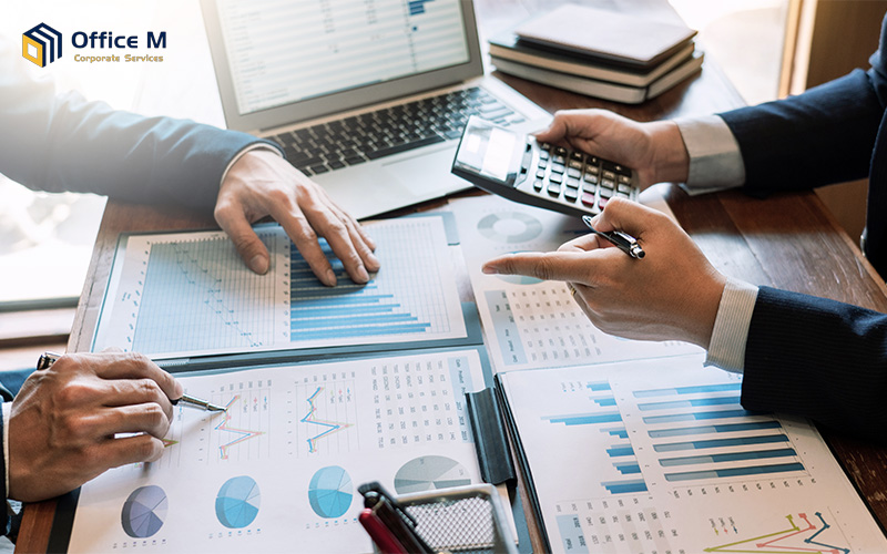 Business professionals discussing financial data and calculating tax strategy